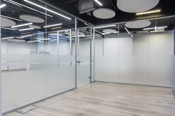 Empty office space with glass floor-to-ceiling windows.