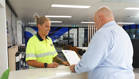 O'Brien® staff member reviewing a clipboard with a customer.