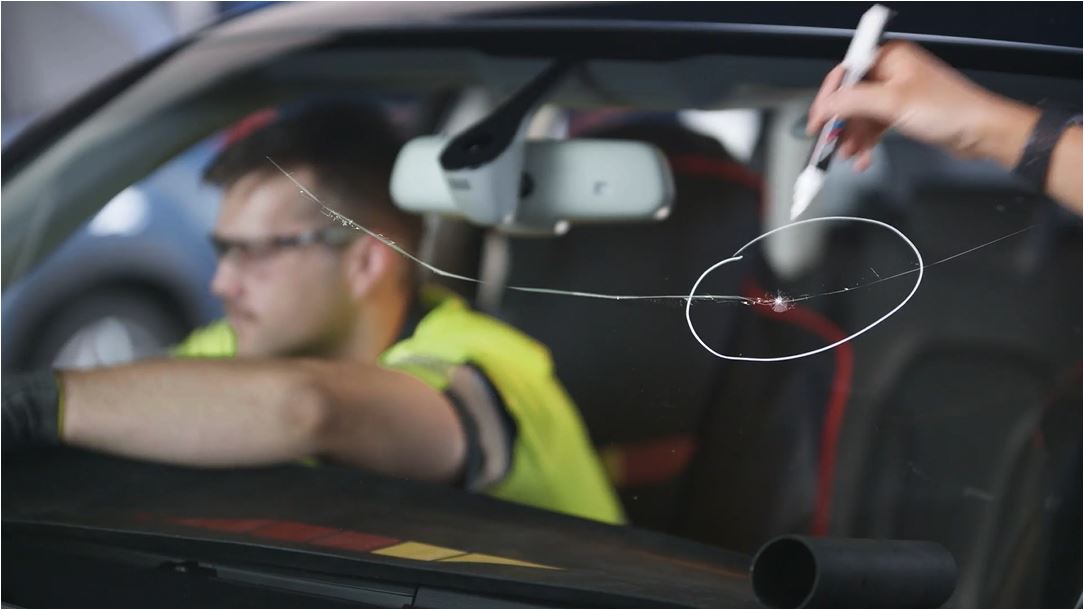 O'Brien® staff member inside a car repairing a chipped windscreen.