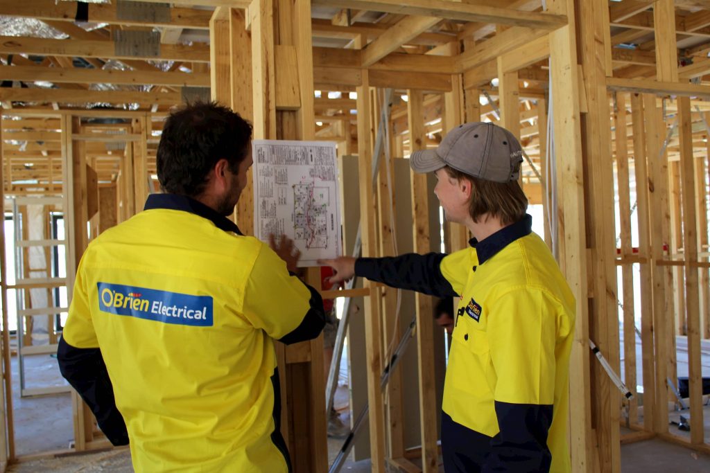 Bendigo Electricians looking at plans on job site 