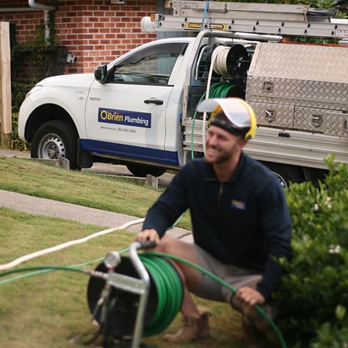 An expert plumber fixing a blocked drain at a home on the Central Coast