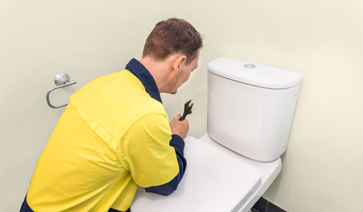 A plumber fixing a toilet in Brisbane Southside