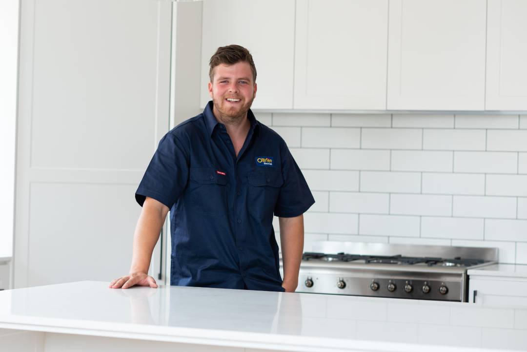 An electrician standing in a home kitchen