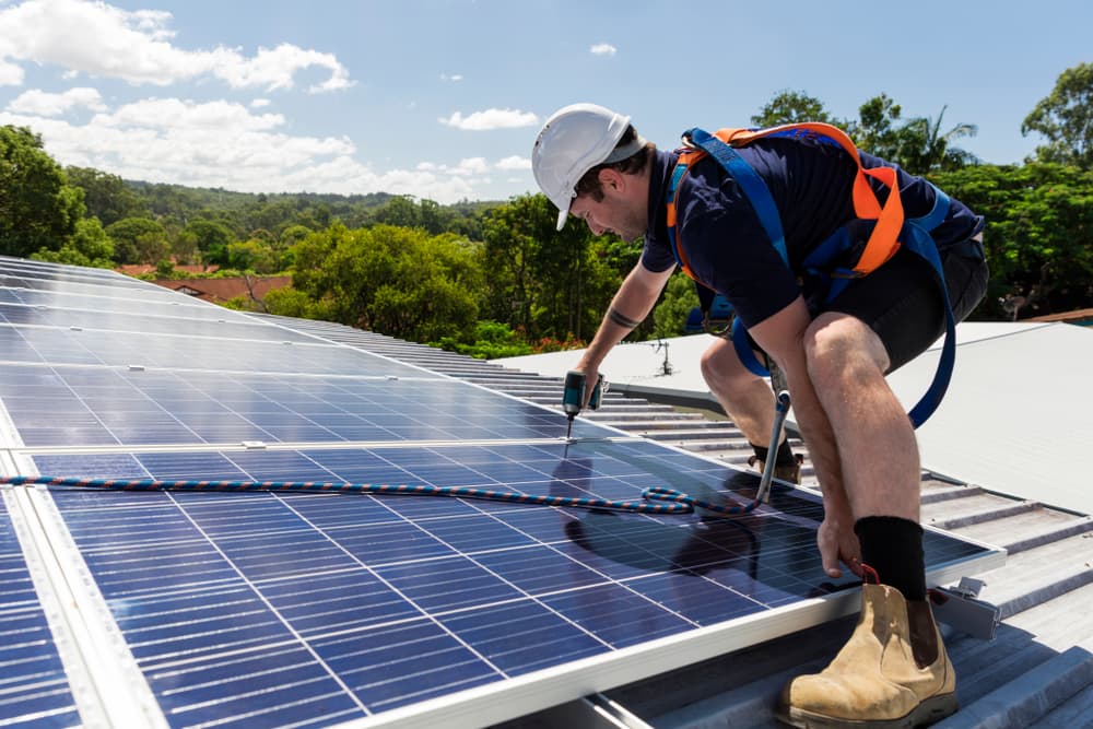 electrician installing solar panel on a roof 