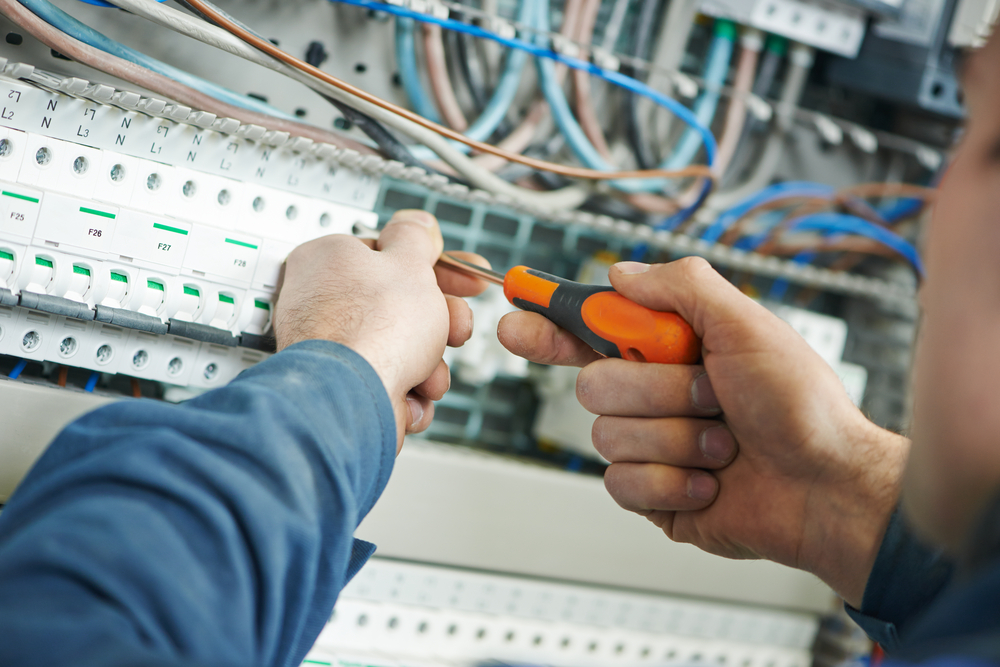 An electrician installing a switchboard in a commercial building