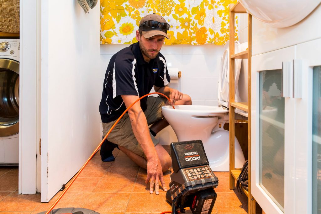 Plumber using CCTV drain inspection to clear blocked drain - Wollongong