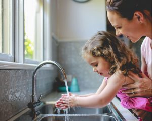 mother-helping-daughter-wash-hands