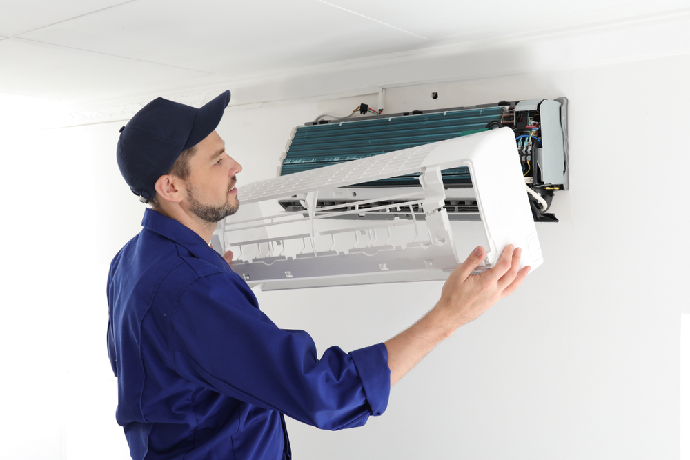 An electrician completing an air conditioner service in Noosaville