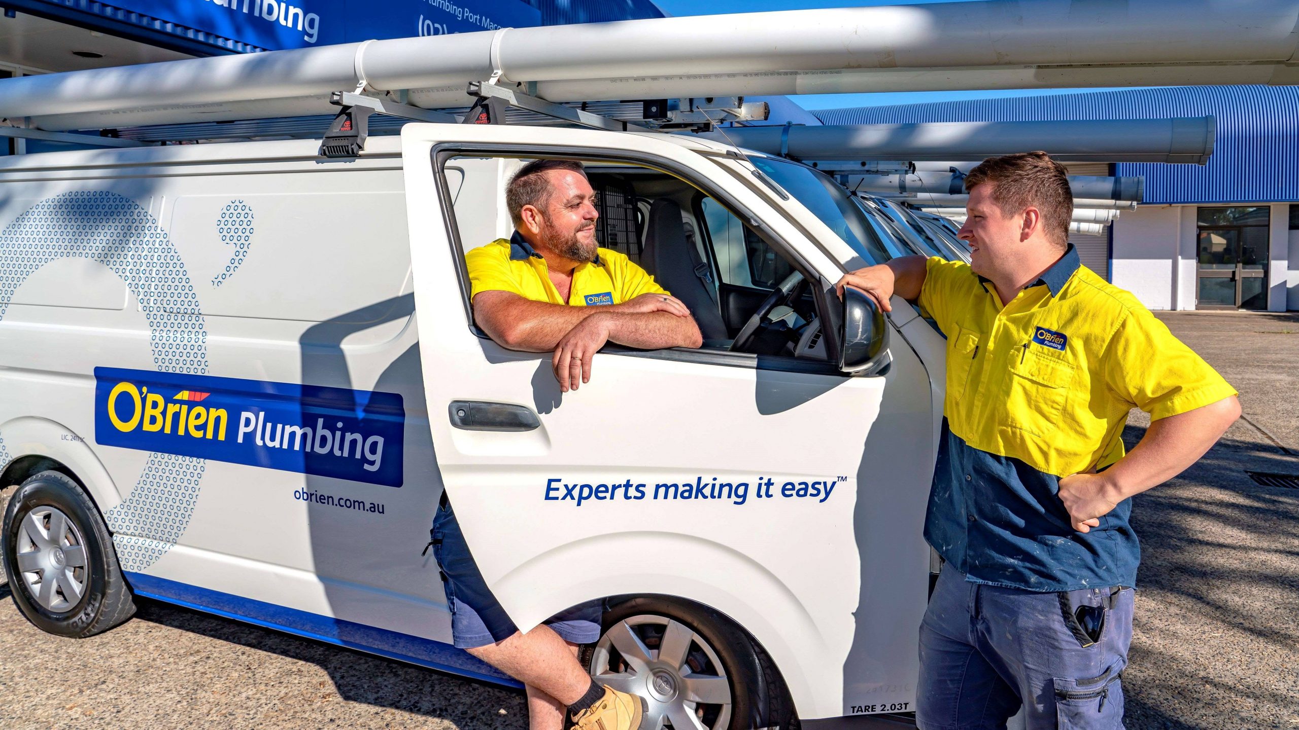 Two expert plumbers from O'Brien Plumbing and Roofing Coffs Harbour at their van.