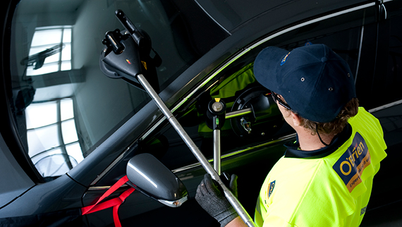 O'Brien® staff member replacing a windscreen on a black car.