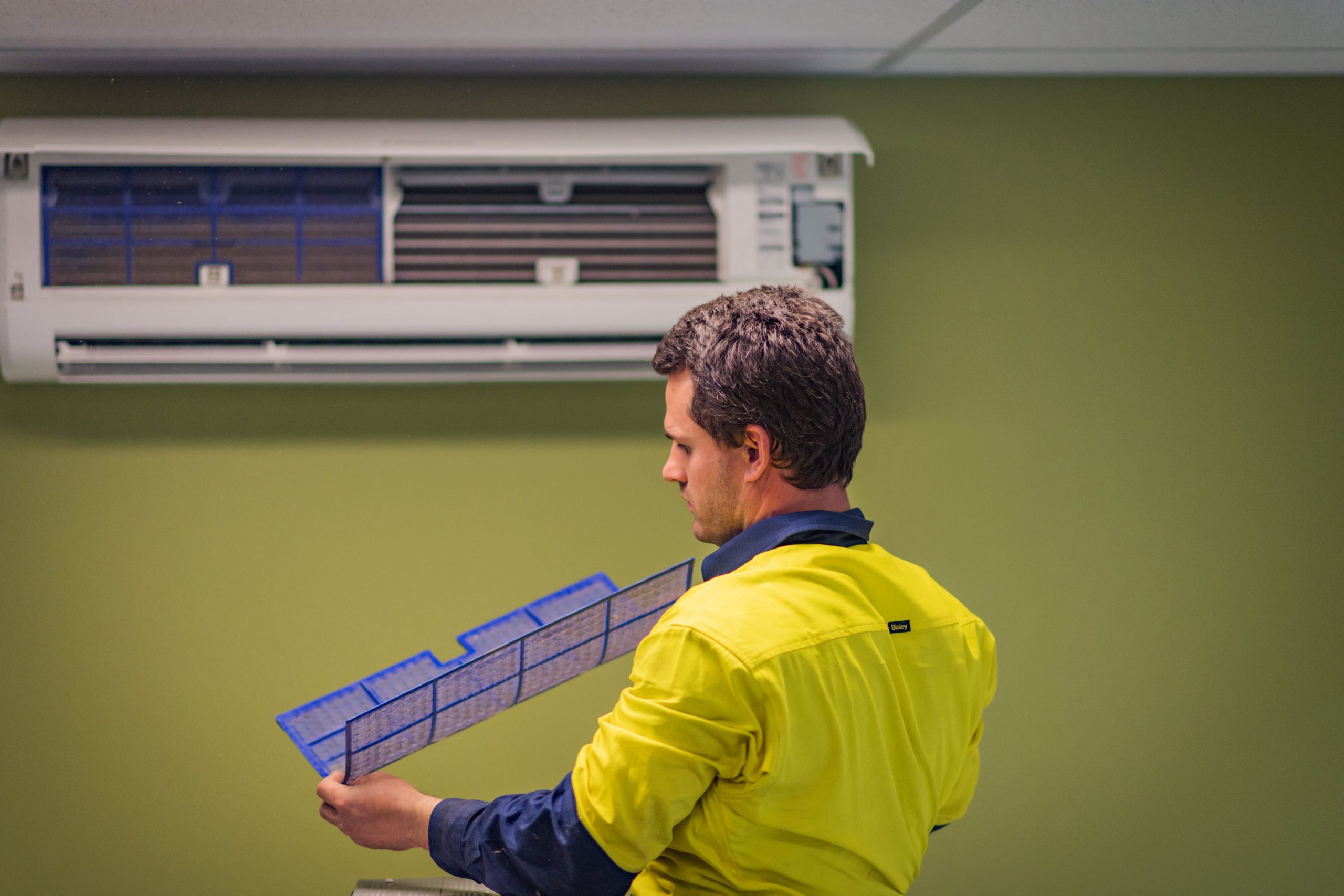 Electrician-completing-air-conditioner-service