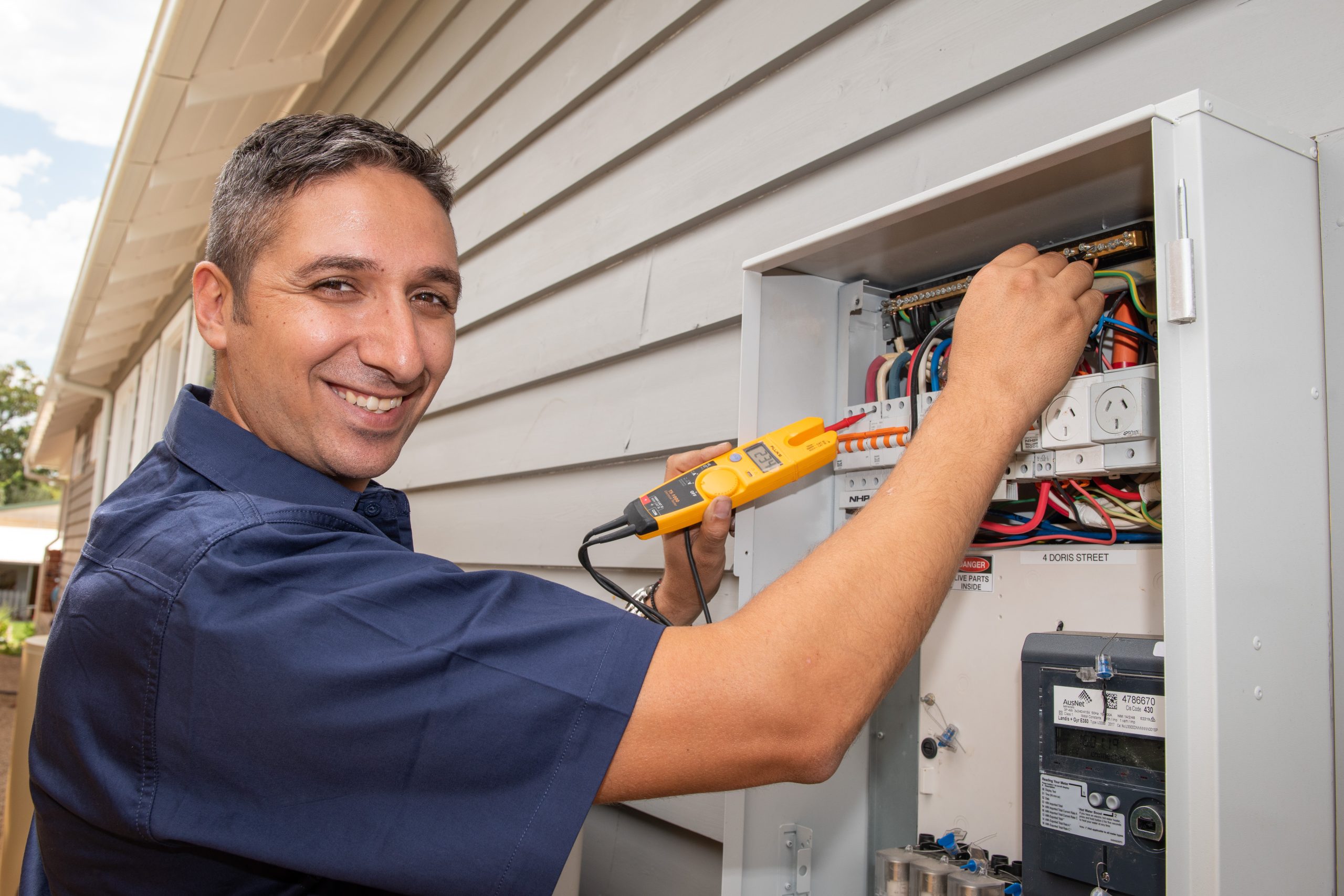 An electrician testing a switchboard