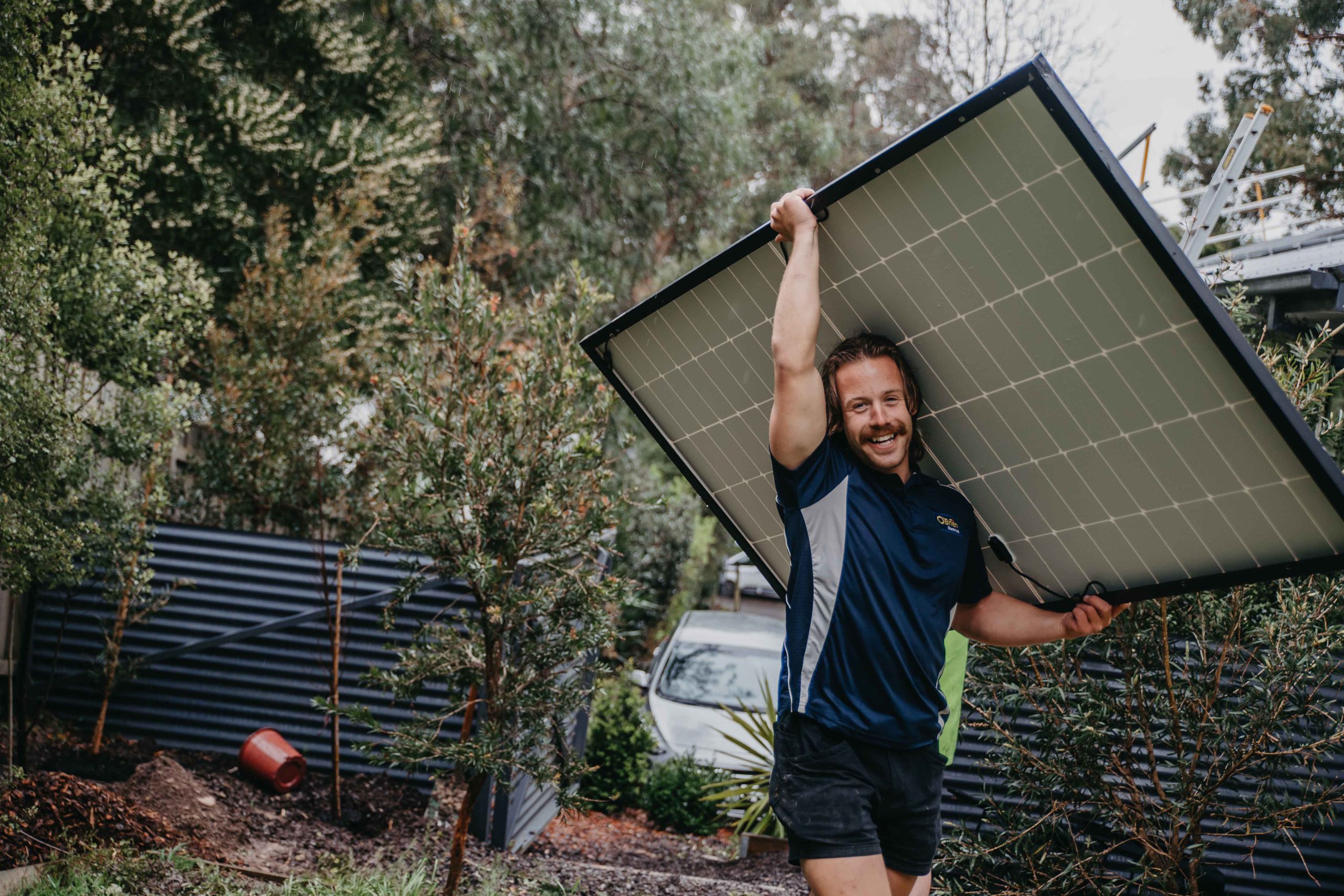 An electrician carrying a solar panel