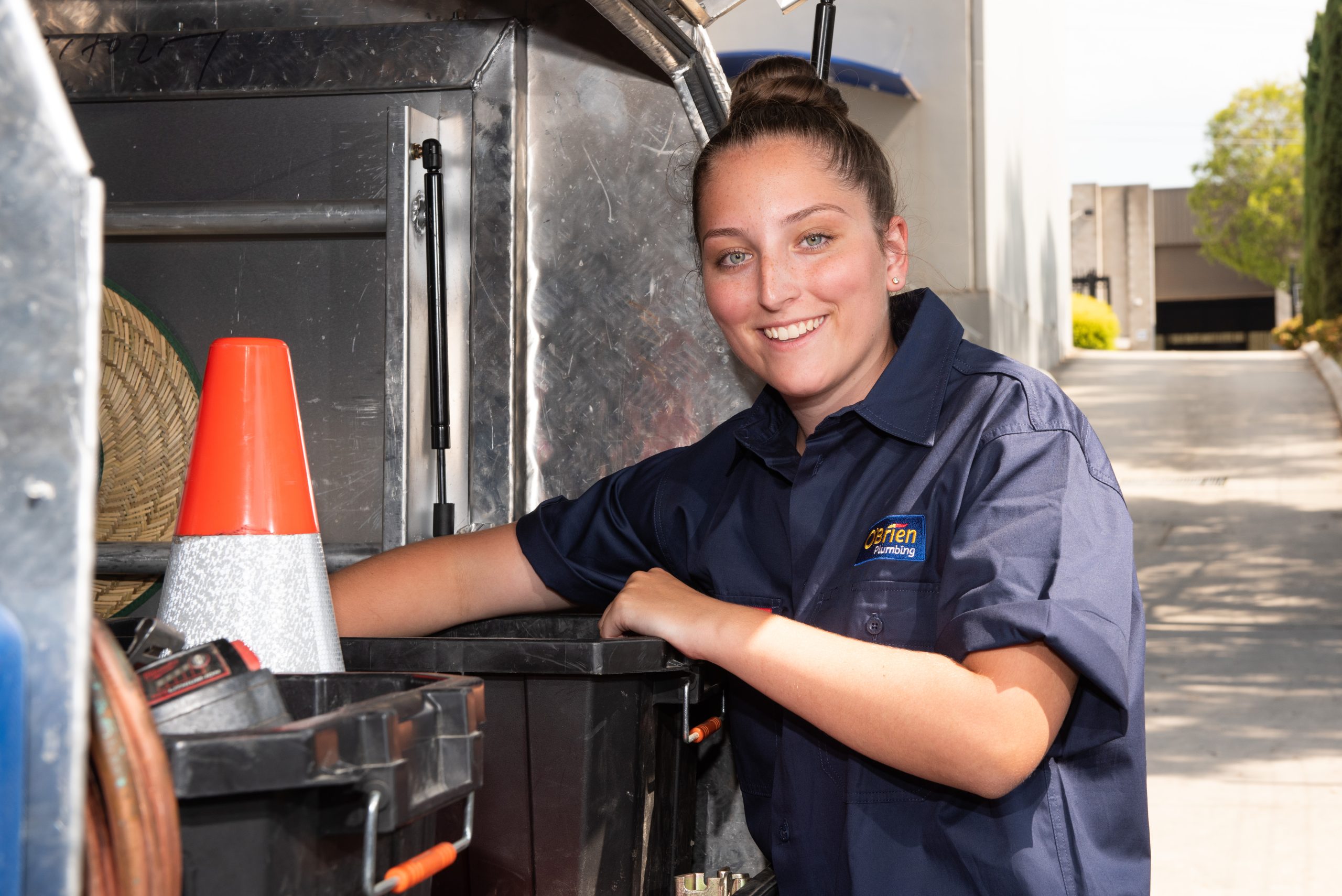 female plumber beside service vehicle