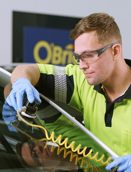 Vehicle glass technician fixing a chipped windshield