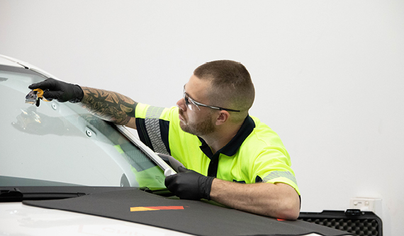 Vehicle glass technician replacing a car's windshield